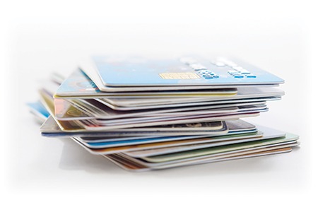 Uneven stack of debit and credit cards against a white background