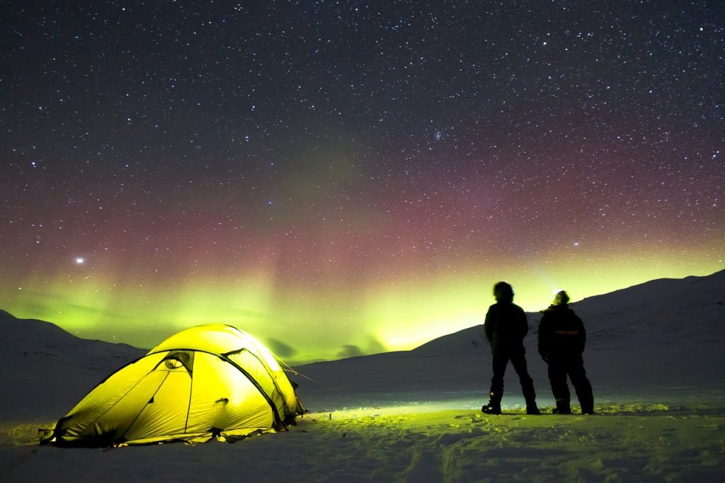 Loyalty Marketing - two people looking at the Aurora Borealis near their tent