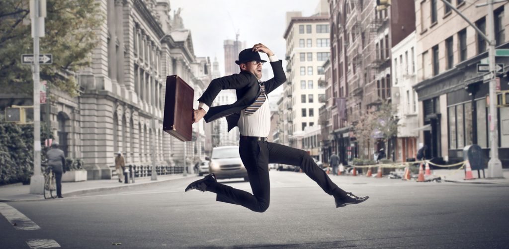 man with briefcase running across street holding hat - loyalty program definition