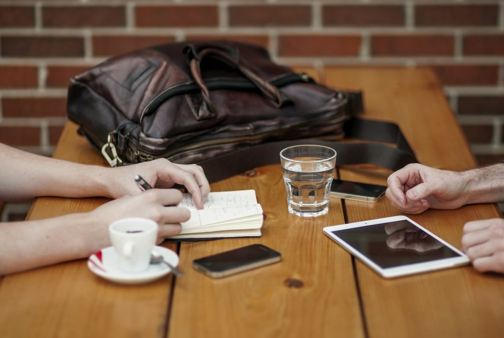 Loyalty Programs For Small Businesses - two people working at a table in a coffee shop