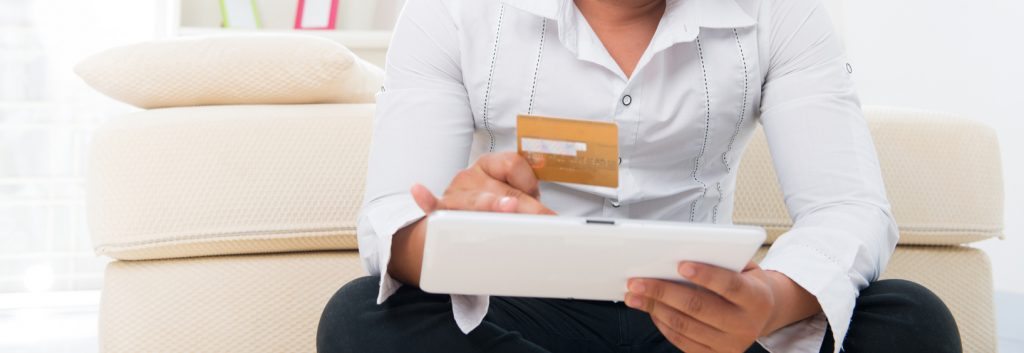 Merchant Solutions - Man purchasing something on a tablet with a credit card